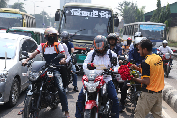 পথচারী ও চালকদের ফুল দিল সাউদি লুব্রিকেন্টস