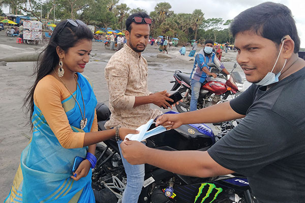 কুয়াকাটায় পর্যটকদের মাঝে মাস্ক বিতরণ 