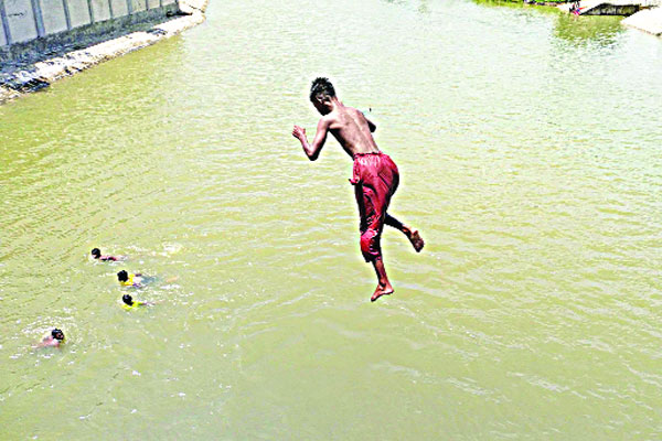 গা জুড়াতে পানিতে দুরন্তপনায় মেতেছে কিশোর