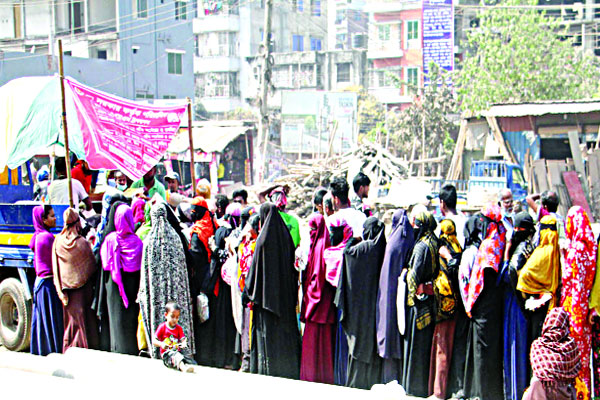 ওএমএস-এর ট্রাকের সামনে মানুষের দীর্ঘ লাইন