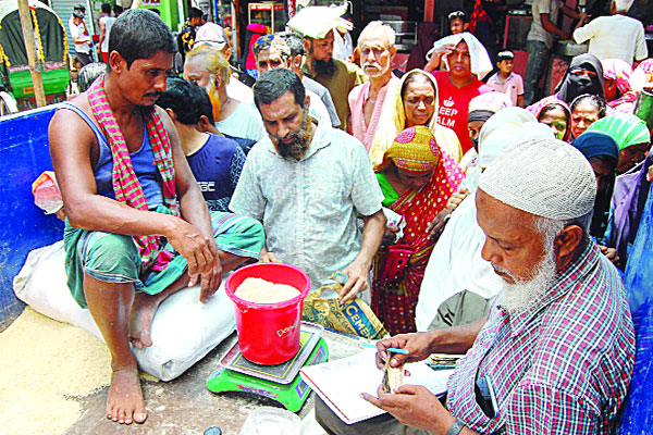 তীব্র রোদ উপেক্ষা করে ওএমএসের চাল ও আটা সংগ্রহ