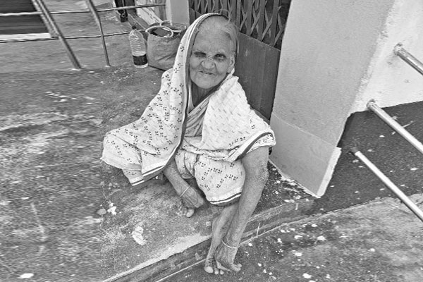 বৃদ্ধার দিন কাটছে অন্যের বাড়ির বারান্দায়