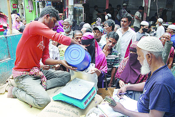 ওএমএসের থেকে চাল ও আটা সংগ্রহ করছেন এলাকাবাসী