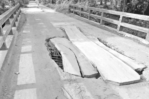 ভাঙা সেতুতে তক্তা বিছিয়ে চলাচল