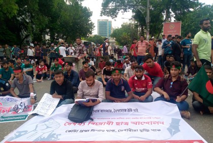 সড়ক অবরোধ করে বই পড়ছেন আন্দোলনকারী শিক্ষার্থীরা


