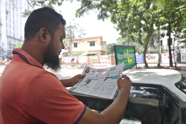 পত্রিকা পড়ছেন এক ব্যক্তি